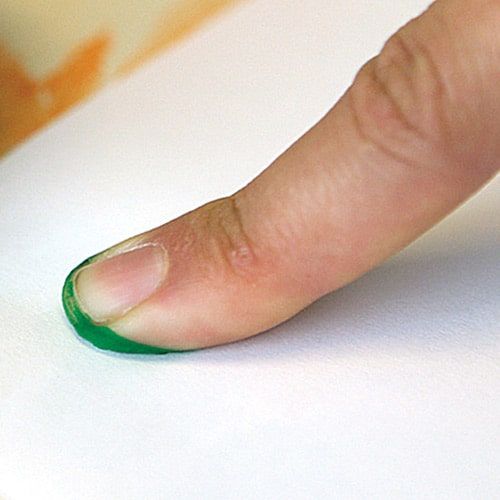 Ucu yeşil boyalı işaret parmağı kağıdın üstünde, iz bırakmaya hazır