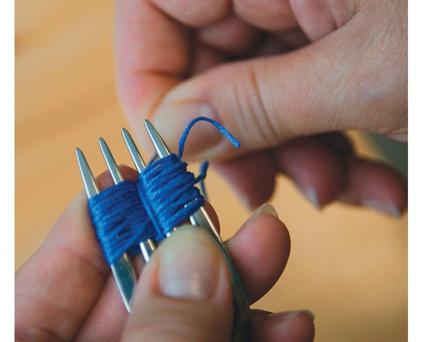 Çatal dişlerine sarılı mavi ip demetinin ortası ayrı bir iple bağlanıyor, yakın çekim