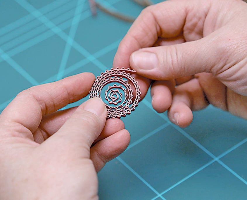 Sarılan oluklu mukavva göbeğinin halkaları parmaklarla hafifçe gevşetilip açılıyor
