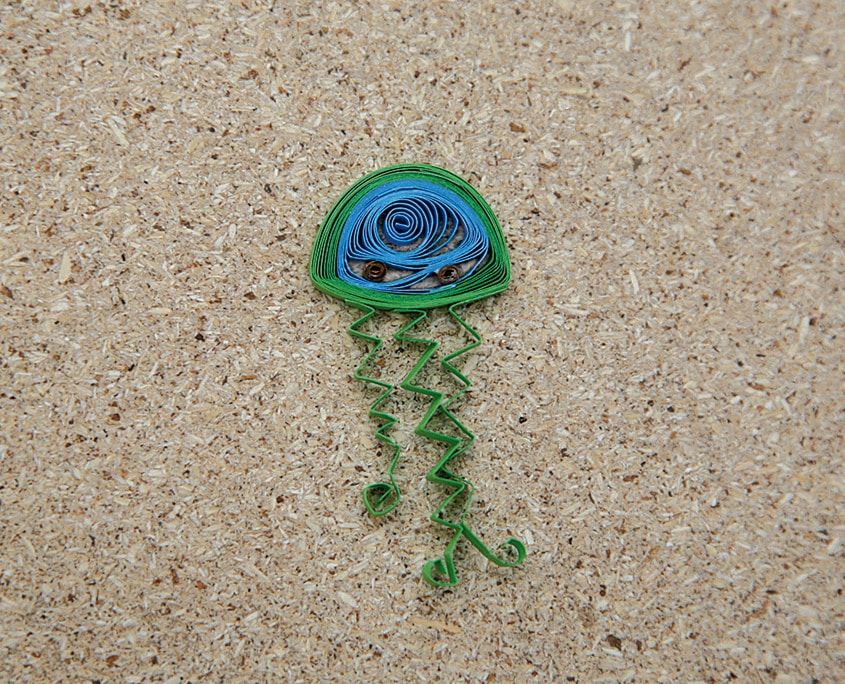 Mavi-yeşil yarım daire gövdeli, kıvrık yeşil dokunaçlı quilling denizanası
