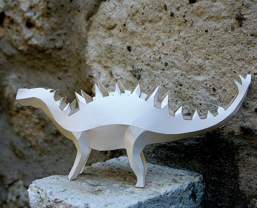 Kağıt dinozorlar etkinliğinden sırtı dikenli, dört bacaklı beyaz kağıt dinozor taş üzerinde