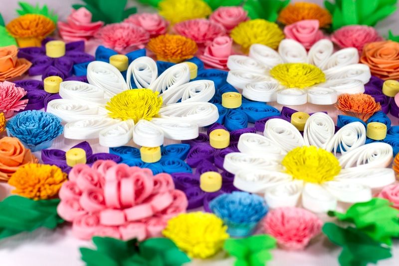 Beyaz papatyalar, pembe ve turuncu püsküllü çiçeklerle dolu yoğun renkli quilling çiçek bahçesi