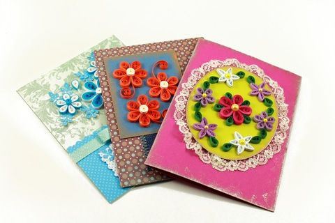 Quilling ile neler yapabilirsiniz: mavi, kırmızı ve pembe kağıt dolama çiçeklerle süslenmiş üç el yapımı kart