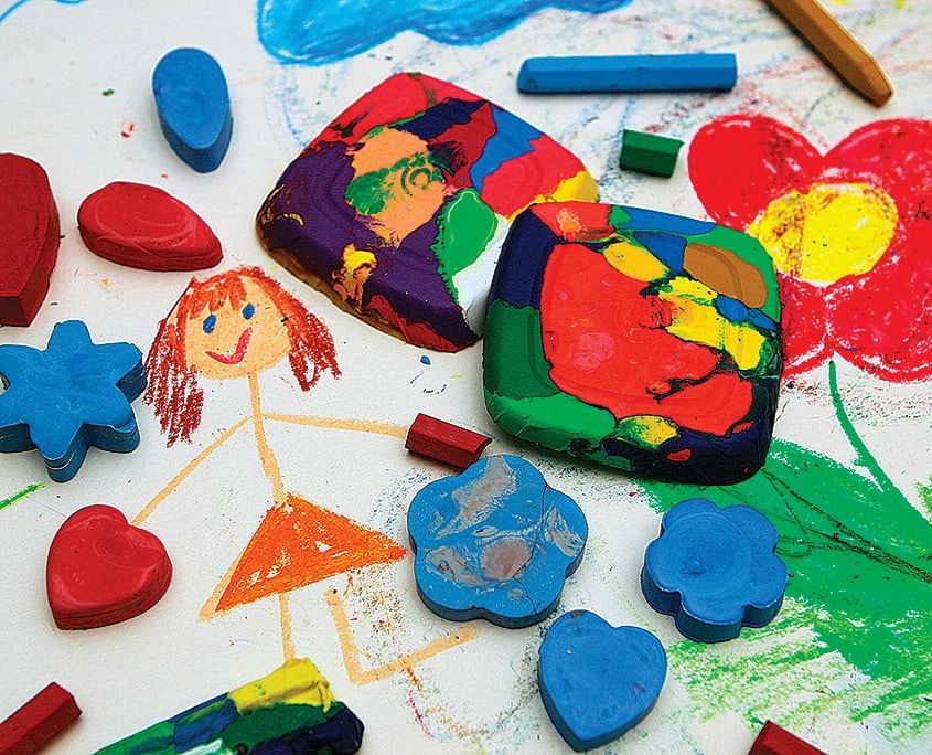 Çok renkli yeni pastel boyalar, bunlarla çizilmiş çiçek ve kız resminin üzerinde dağınık duruyor