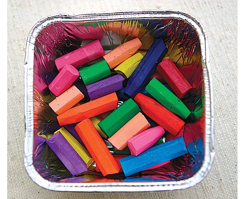 Alüminyum kapta kağıtları soyulup küçük parçalara kırılmış rengarenk pastel boyalar