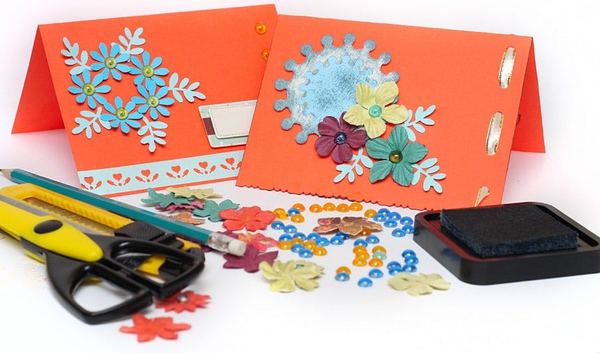 Quilling çalışmalarında gerekli malzemeler: kağıt dolama çiçekli turuncu kartlar, makas, maket bıçağı ve ıstampa