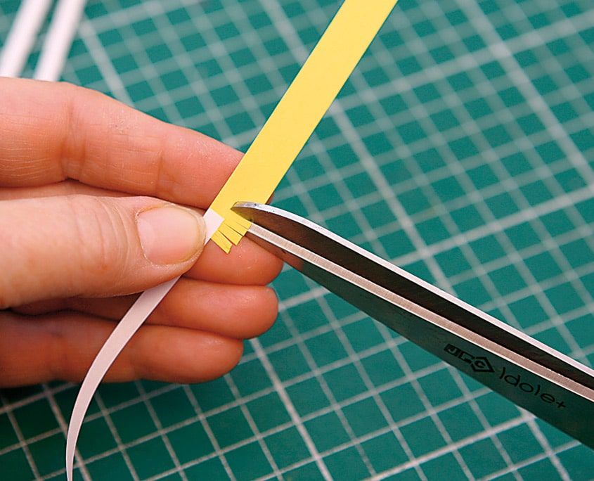 Sarı quilling şeridinin bir kenarı makasla sık aralıklarla kesilerek saçaklandırılıyor