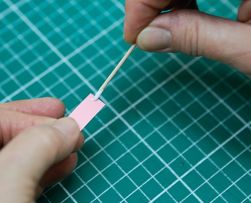 Pembe quilling şeridinin ucu yarıklı çubuğa takılıp parmaklar arasında sarılmaya başlanıyor