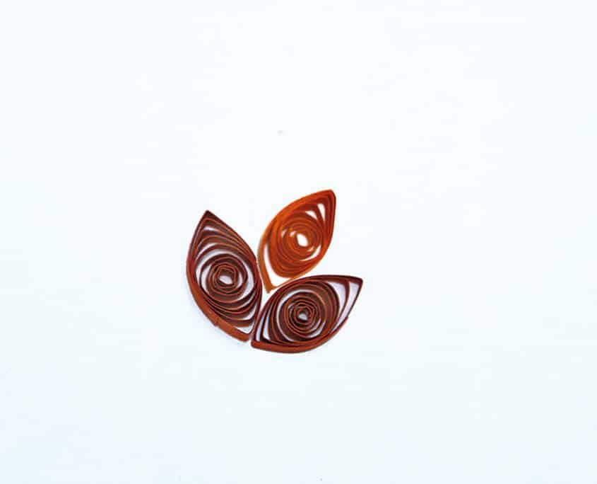 Üç damla quilling parçasının birleşmesiyle oluşmuş kırmızı-kahverengi lale çiçeği