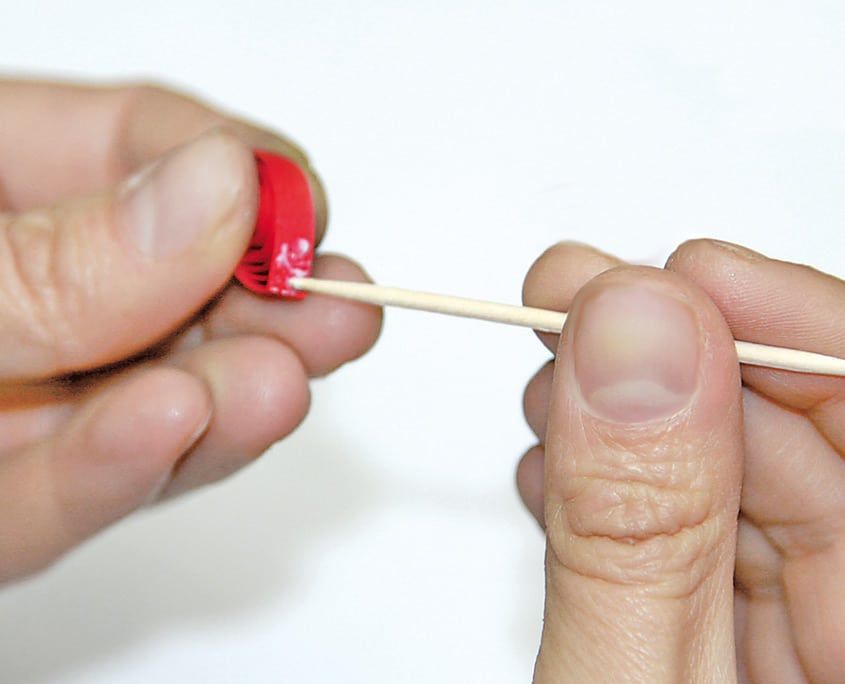 Kırmızı damla quilling parçasının kenarına kürdanla tutkal sürülüyor