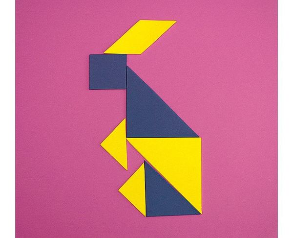 Pembe zeminde sarı ve lacivert tangram parçalarıyla kurulmuş dik duran bir figür