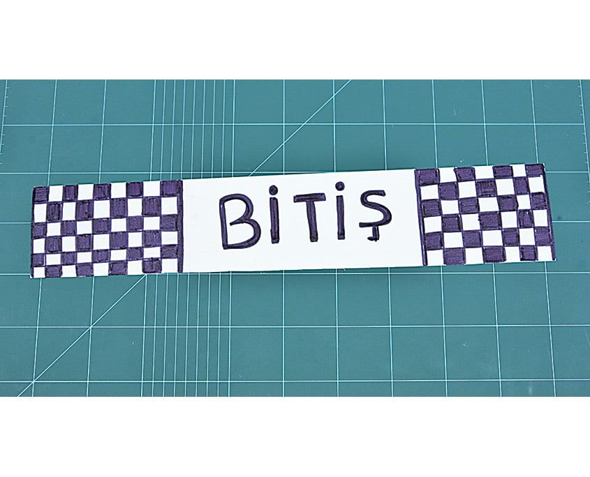 Kesim matında damalı kenarlı beyaz şerit üzerine yazılmış Bitiş pankartı