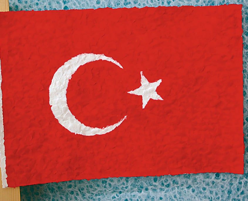 Yırtılmış kırmızı kağıt parçalarıyla kaplanmış, beyaz ay yıldızlı tamamlanmış Türk bayrağı