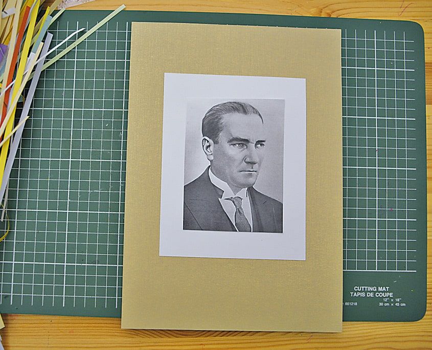 Bej paspartu kartona yapıştırılmış siyah-beyaz Atatürk portresi, yanında quilling şeritleri