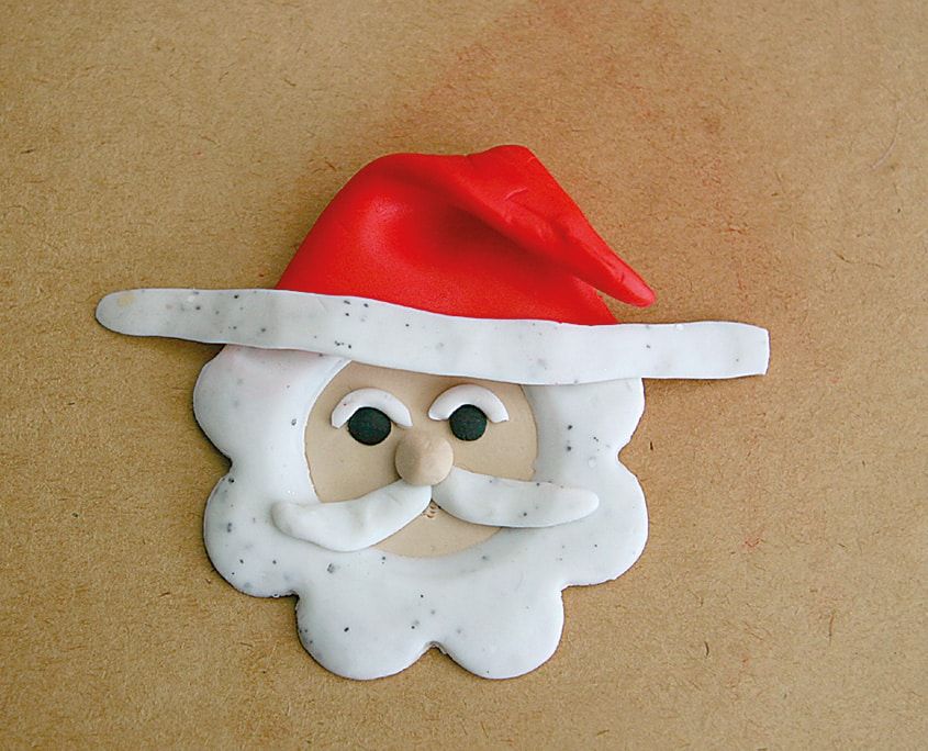 Kırmızı şapkası kıvrık ve beyaz kil kenarlı tamamlanmış kil Noel Baba yüzü