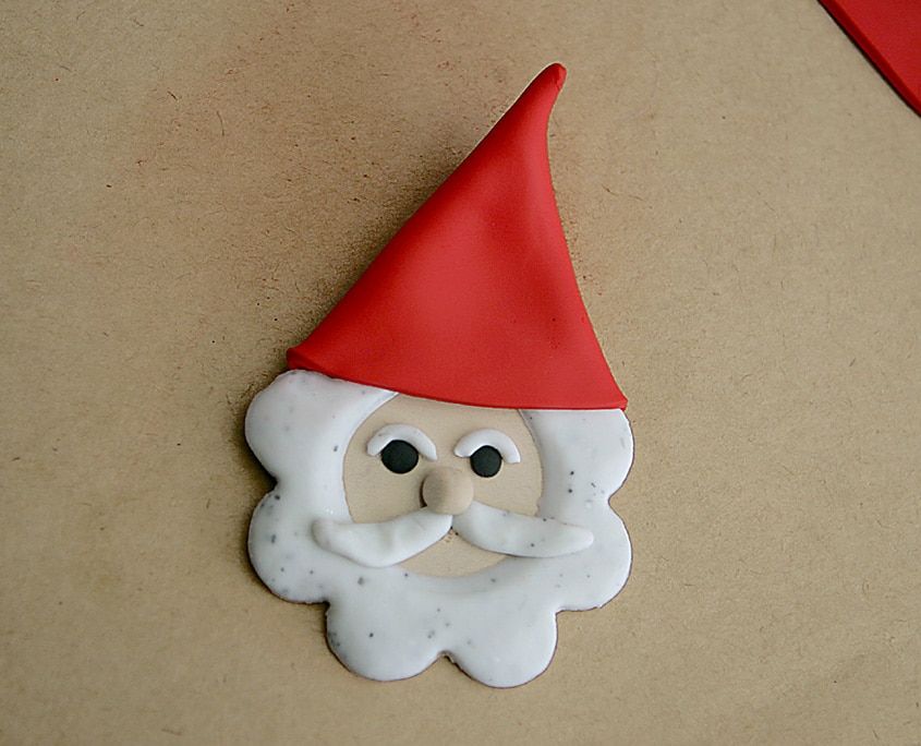 Kil Noel Baba yüzünün üstüne sivri kırmızı kil üçgen şapka yerleştirilmiş