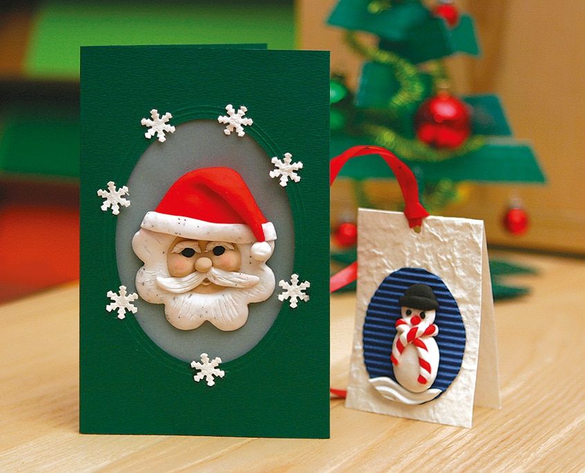 Kilden Mini Yeni Yıl Kartları: oval pencerede kil Noel Baba yüzlü yeşil kart ve kil kardan adamlı gümüş kart