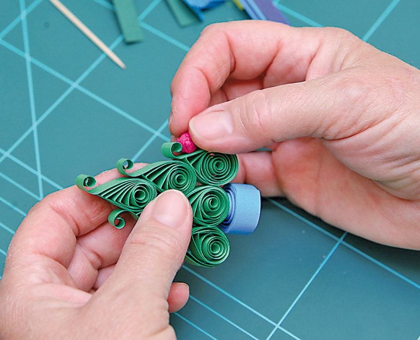 Yeşil quilling ağacın dallarına pembe top süsün yapıştırılması