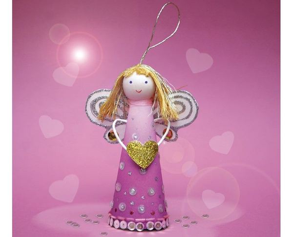 Melek süs: pembe konik etekli, sarı saçlı, yaldızlı kanatlı ve altın kalpli kağıt melek, pembe fonda