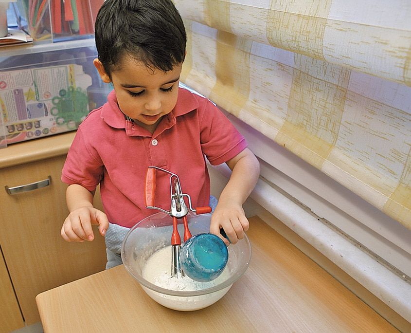 Kaseye eklenen süt ve un karışımı mikserle çırpılmaya hazırlanıyor, çocuk başında bekliyor