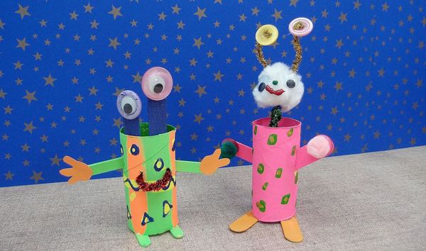 Çılgın uzaylılar: yeşil ve pembe boyanmış karton rulolardan, oynar gözlü ve pompon başlı iki uzaylı figürü