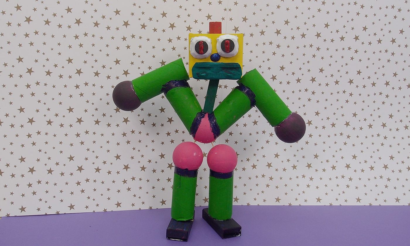 Bay Robot: yeşil silindirler, pembe ve mor toplarla yapılmış eklemli robot, oynar gözlü sarı kafa