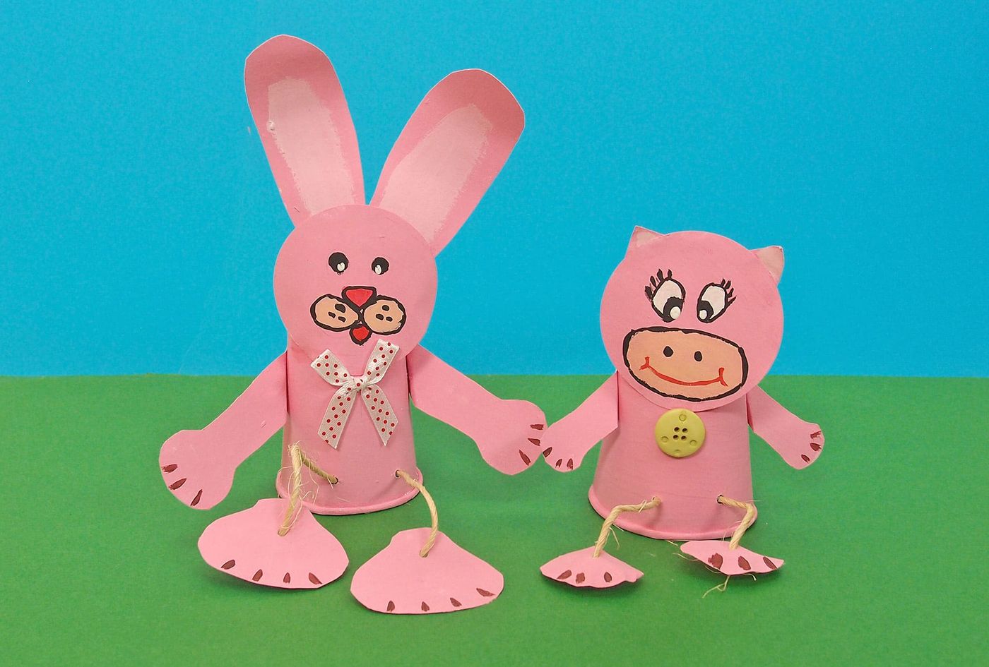 Pembe Kardeşler: pembe kartondan kurdeleli tavşan ve düğmeli domuz, akordeon kağıt bacaklarla