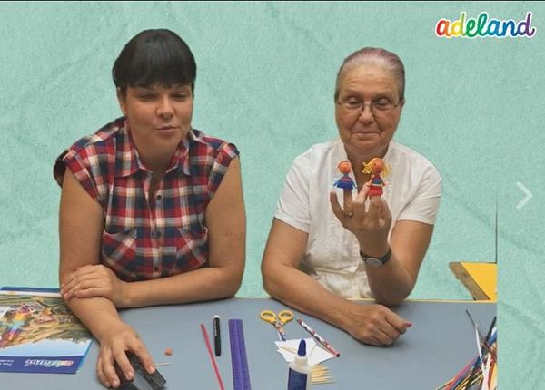 3D quilling kuklalar canlı atölye yayınından kare: iki eğitmen masada, biri parmağında kuklaları gösteriyor