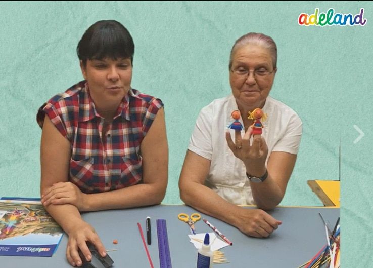 3D quilling kuklalar canlı atölye yayınından kare: iki eğitmen masada, biri parmağında kuklaları gösteriyor