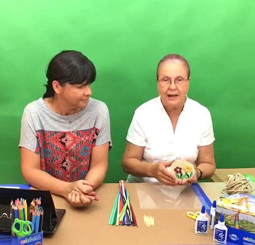 Quilling ile buzdolabı mıknatısı yayınından kare: iki eğitmen masada, biri hazır mıknatısı gösteriyor