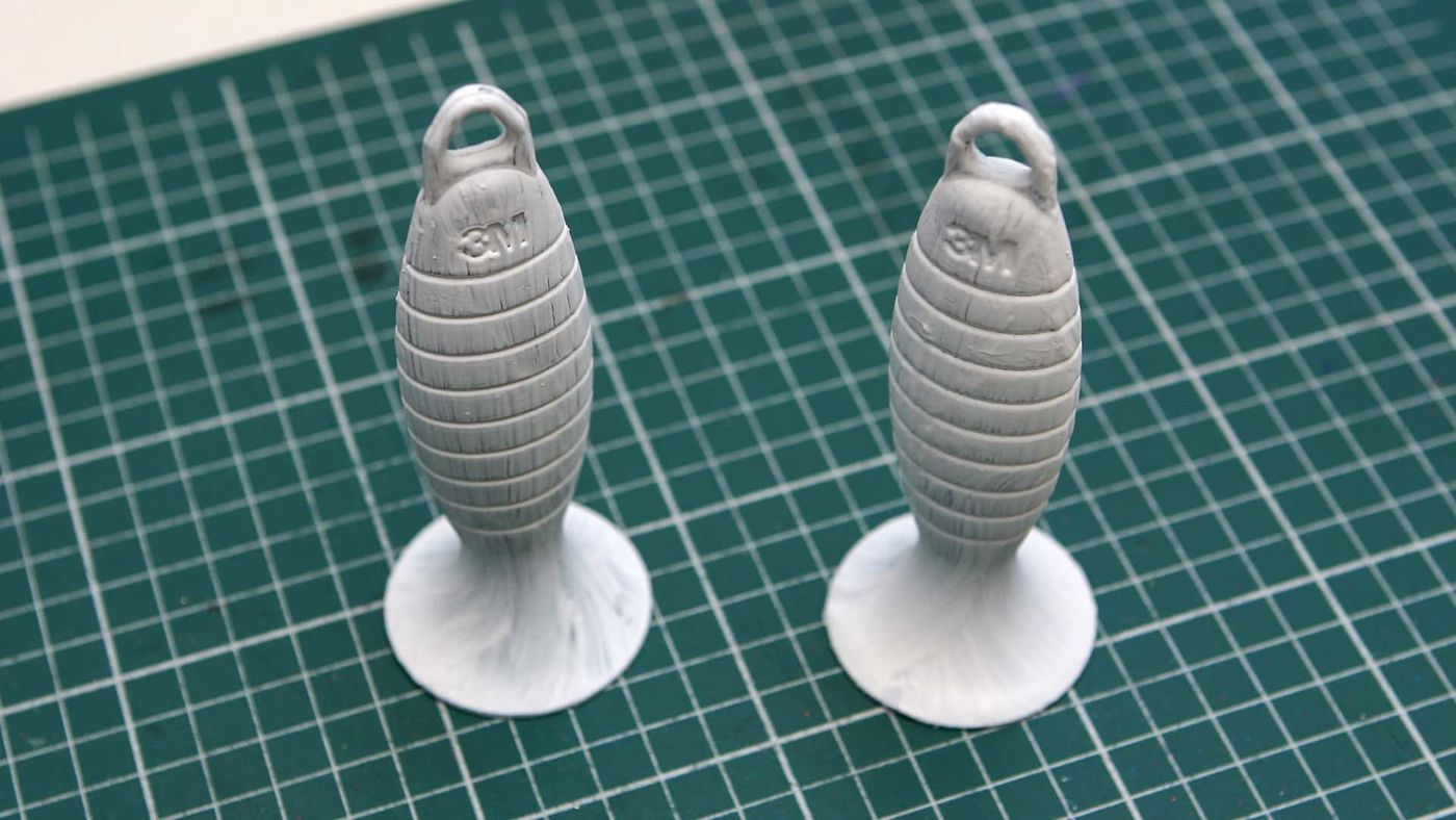Marakas sapı olarak kullanılacak tırtıklı iki gri plastik parça, kesme matı üzerinde