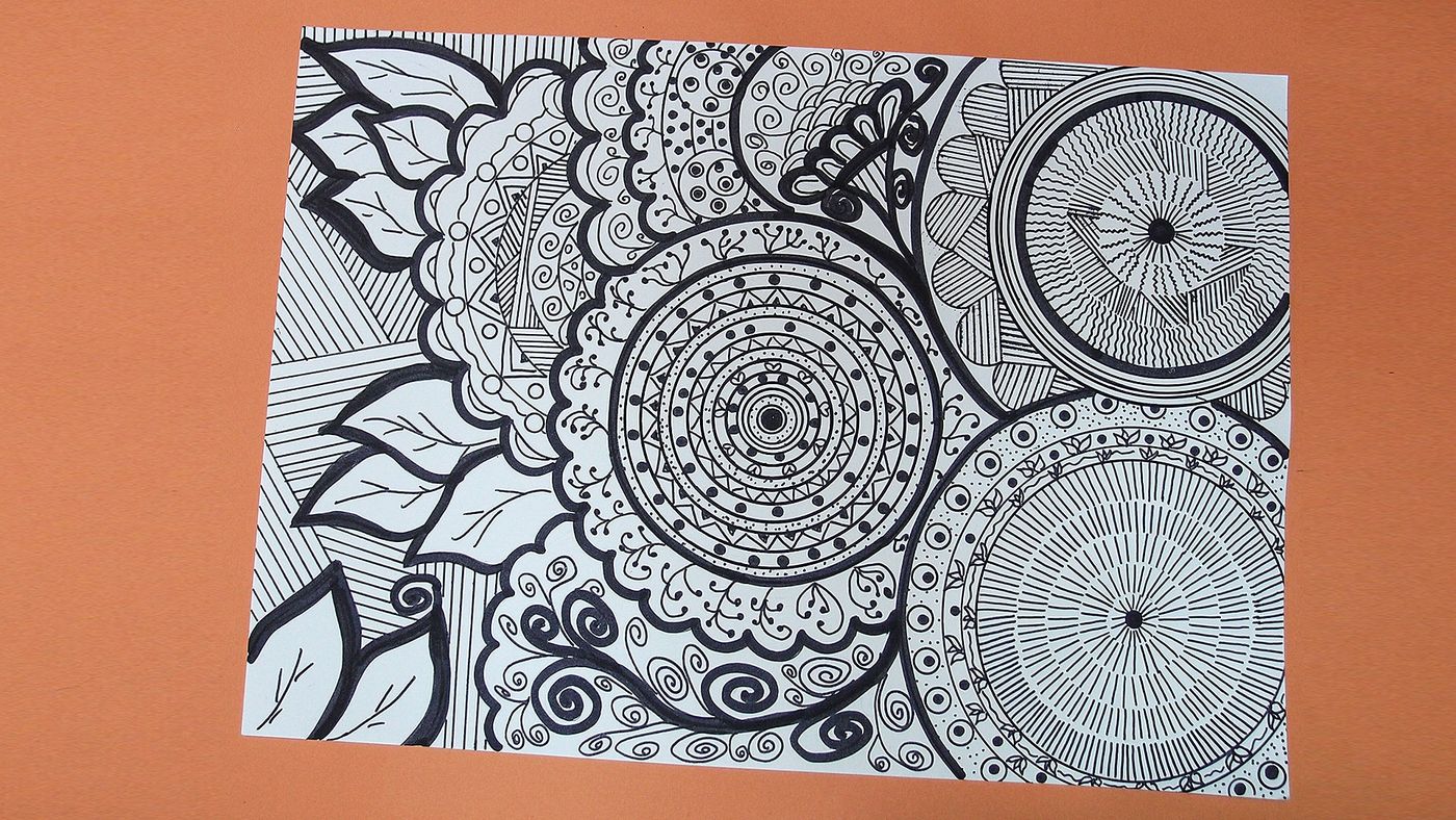 Siyah kalemle çizilmiş doodle çalışması: daire mandalalar, yapraklar ve spiraller turuncu zeminde