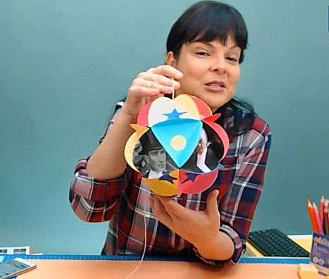 Canlı atölye yayınından kare: eğitmen resim küresi çalışmasını, fotoğraflı renkli kağıt küreyi gösteriyor