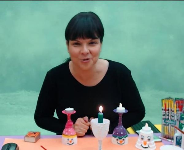 Bardak Mumluklar video karesi: eğitmen masadaki kardan adam yüzlü bardak mumlukları gösteriyor