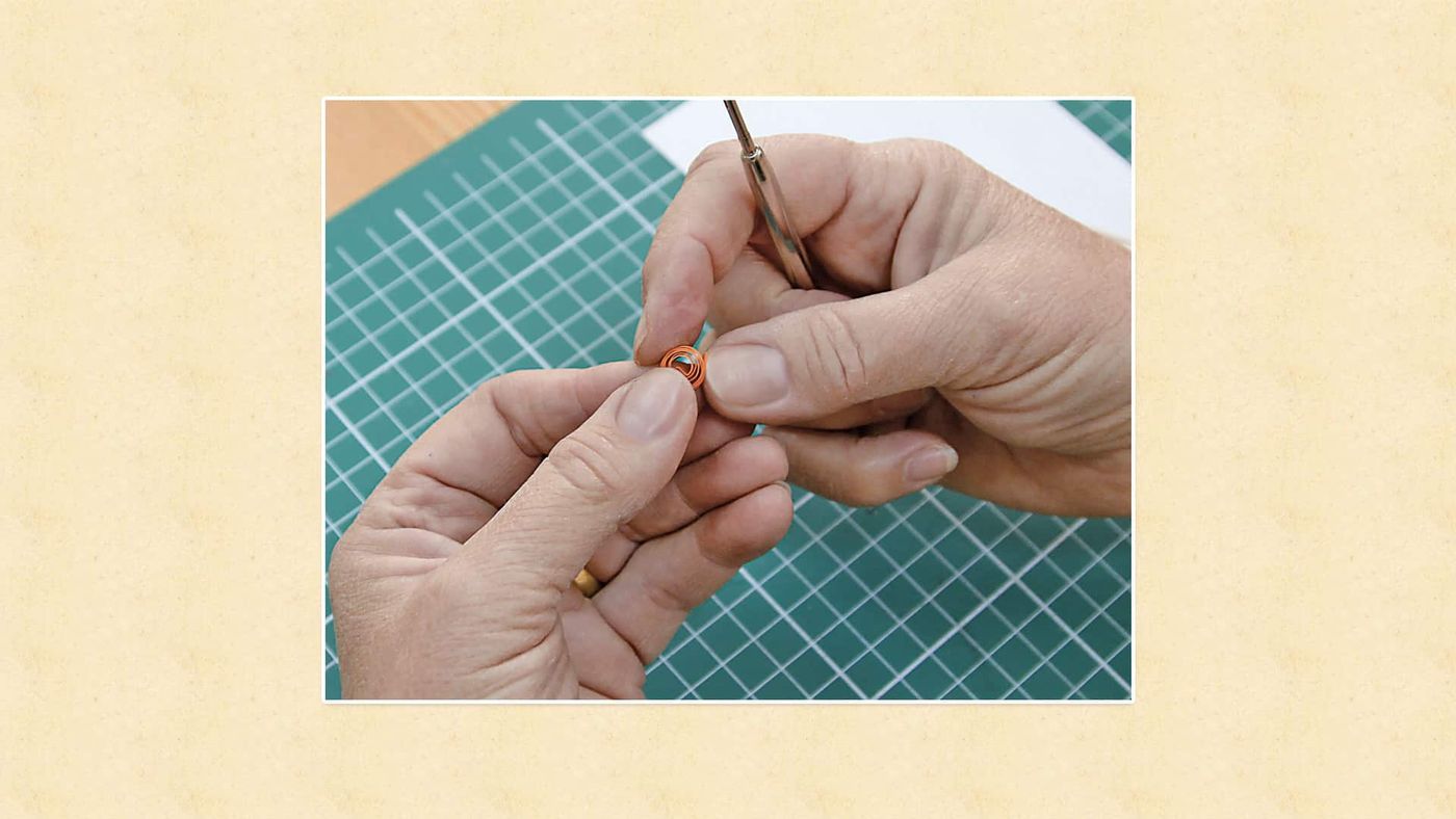 Quilling kalemi çevrilerek turuncu kağıt şerit sıkıca sarılıp küçük rulo yapılıyor