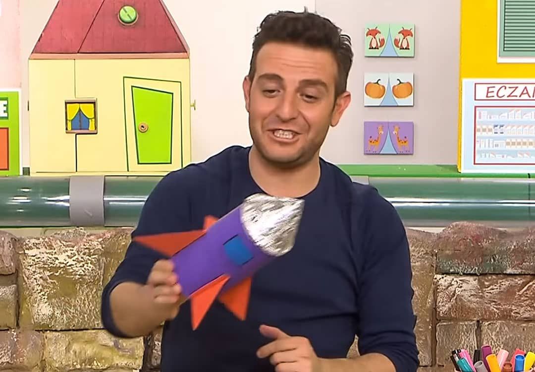 Füze kalemlik yapımı video karesi: sunucu kanatlı mor füze kalemliği elinde tutuyor