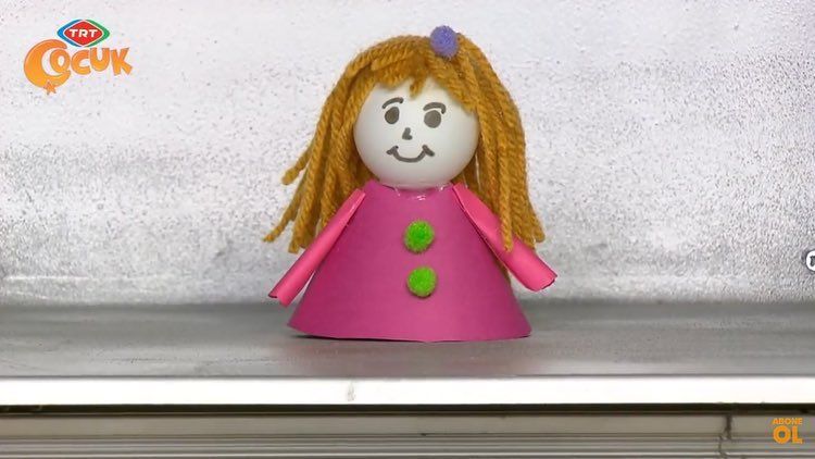 Pembe koni gövdeli, sarı yün saçlı ve yeşil düğmeli kağıt kız hacıyatmaz
