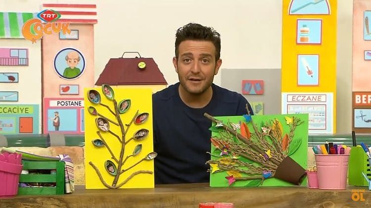 Televizyon programından kare: sunucu dal ve fotoğraflarla yapılmış iki soy ağacı panosunu gösteriyor