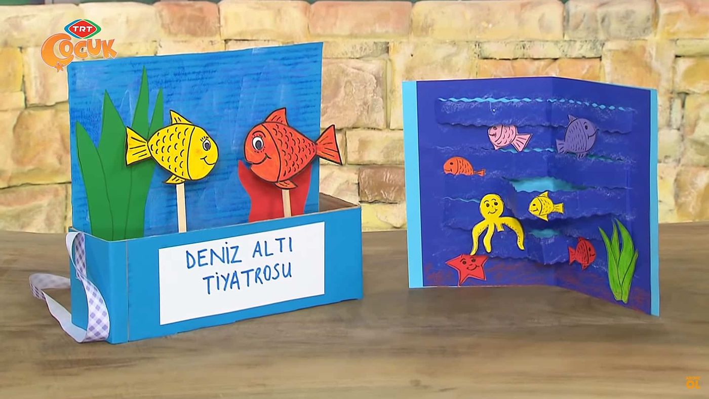 Deniz altı tiyatrosu: ahşap masada omuz askılı karton kutu sahne ve yanında balıklı, ahtapotlu açılır deniz sahnesi