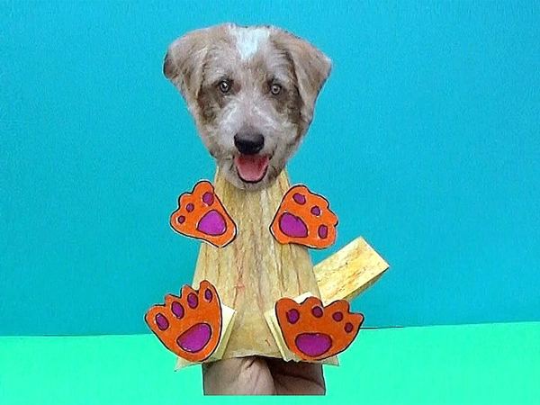 Kağıttan köpek el kuklası: köpek başı fotoğrafı, krem gövde, turuncu pençeler ve sallanan kuyruk