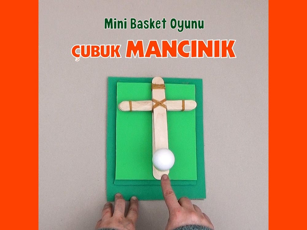 Mini basket oyunu için çubuk mancınık: yeşil kartona tutturulmuş dondurma çubukları ve üzerinde beyaz top