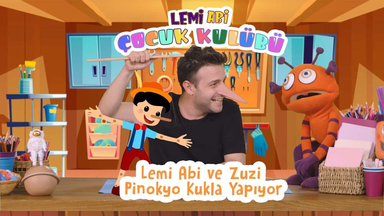 Burnu Uzayan Pinokyo kukla yapımı video kapağı: sunucu kağıt Pinokyo kuklayı gösteriyor, yanında turuncu kukla